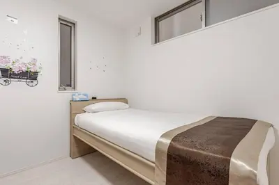 a white room with a bed with a window at \u5c71\u624b\u7dda\u7530\u7aef\u99c5\u304b\u3089\u5f92\u6b695\u5206\u3001\u3068\u3066\u3082\u4fbf\u5229\u306a\u5834\u6240\u3067\u3059 in Tokyo