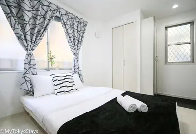 a bedroom with a large white bed with a window at Skytree & Asakusa Easy Access Bell Flat Inn #2 in Tokyo