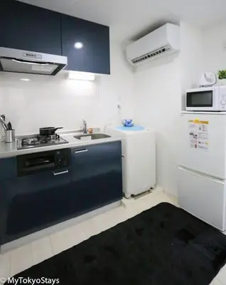 a kitchen with a sink and a stove and a refrigerator at Skytree & Asakusa Easy Access Bell Flat Inn #2 in Tokyo