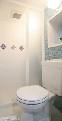 a white bathroom with a toilet and a sink at Skytree & Asakusa Easy Access Bell Flat Inn #2 in Tokyo