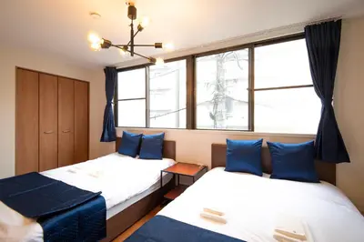 two beds in a room with two windows at \u6d45\u8349classy\u30cf\u30a6\u30b9 in Tokyo