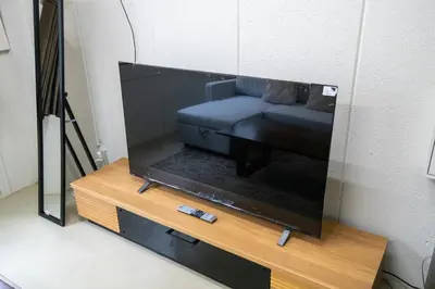a tv screen with a couch on a table at \u6d45\u8349classy\u30cf\u30a6\u30b9 in Tokyo