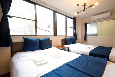 two beds in a room with large windows at \u6d45\u8349classy\u30cf\u30a6\u30b9 in Tokyo