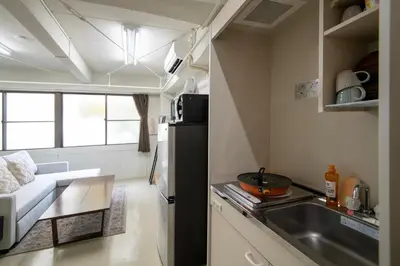 a small kitchen with a couch and a sink in a room at \u6d45\u8349classy\u30cf\u30a6\u30b9 in Tokyo