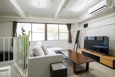 a living room with a couch and a table and a tv at \u6d45\u8349classy\u30cf\u30a6\u30b9 in Tokyo