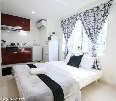 a bedroom with a large bed and a kitchen at Easy Access to Skytree Studio Bell Flat Inn #4 in Tokyo