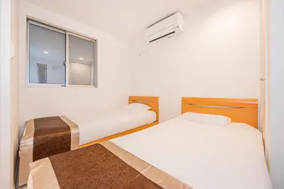 two beds in a small room with a window at SkyTreeStayHotel2\u9418\u30f6\u6df5\u99c5\u304b\u3089\u5f92\u6b694\u5206\u5929\u4e95\u304b\u3089skytree\u304c\u898b\u3048\u307e\u3059 in Tokyo