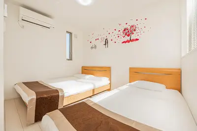 two beds in a room with white walls and a window at SkyTreeStayHotel2\u9418\u30f6\u6df5\u99c5\u304b\u3089\u5f92\u6b694\u5206\u5929\u4e95\u304b\u3089skytree\u304c\u898b\u3048\u307e\u3059 in Tokyo