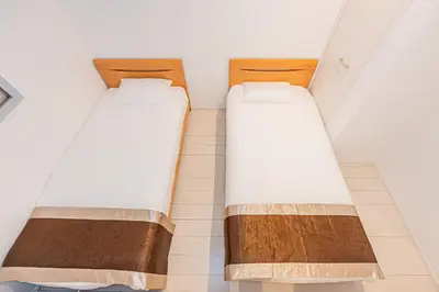 two beds in a room next to a wall at SkyTreeStayHotel2\u9418\u30f6\u6df5\u99c5\u304b\u3089\u5f92\u6b694\u5206\u5929\u4e95\u304b\u3089skytree\u304c\u898b\u3048\u307e\u3059 in Tokyo