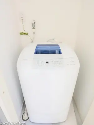 a white washing machine sitting in a room at NEW! Time Square Shibuya Modern Unit. Prime Location in Tokyo