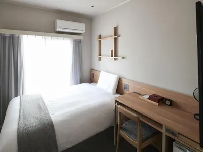 a hotel room with a bed and a desk and a window at Vessel Inn Asakusa Tsukuba Express in Tokyo