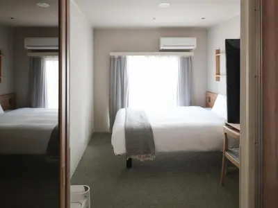 a hotel room with two beds and a window at Vessel Inn Asakusa Tsukuba Express in Tokyo