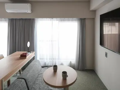 a living room with a couch and a table at Vessel Inn Asakusa Tsukuba Express in Tokyo