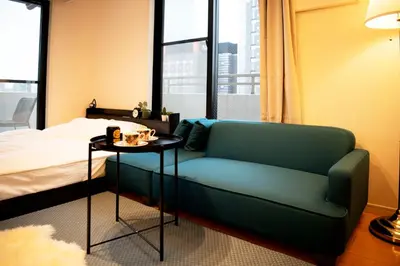 a bedroom with a couch and a bed and a table at #6 stylish apartment with beautiful night view A stop to Shinjuku station in Tokyo