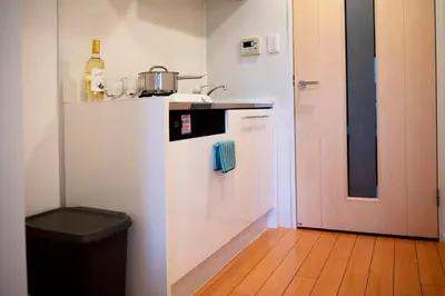 a small kitchen with a white refrigerator and a door at #6 stylish apartment with beautiful night view A stop to Shinjuku station in Tokyo