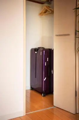a purple suitcase is standing in a room at #6 stylish apartment with beautiful night view A stop to Shinjuku station in Tokyo