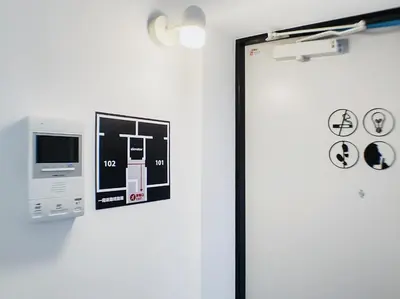 a room with a door with a picture on the wall at SaffronCasa Asakusabashi by Tranova in Tokyo