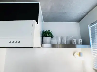 a kitchen with white cabinets and a white microwave at SaffronCasa Asakusabashi by Tranova in Tokyo