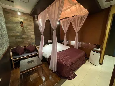 a bedroom with a bed with curtains and a couch at Hotel THE ATTA Adult Only in Tokyo