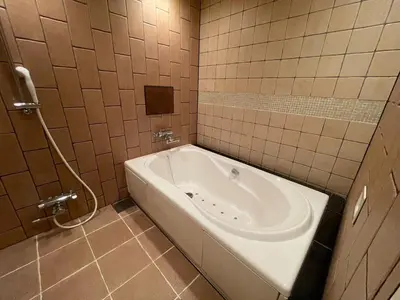 a bathroom with a tub in a tiled room at Hotel THE ATTA Adult Only in Tokyo