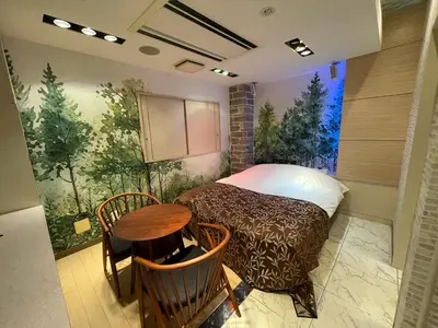 a bedroom with a bed and a table in it at Hotel THE ATTA Adult Only in Tokyo