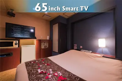 a bed in a hotel room with a tv at Hotel Will\u6c60\u888b Adult Only in Tokyo
