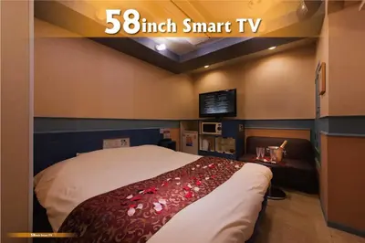 a bedroom with a large bed with a red blanket at Hotel Will\u6c60\u888b Adult Only in Tokyo