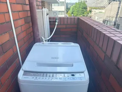 a washing machine sitting on the side of a brick wall at \u65b0\u5bbf\u5e02\u4e2d\u5fc3JR\u7ebf\u65b0\u5927\u4e45\u4fdd\u4e09\u5206\u949f\u7d27\u90bb\u97e9\u56fd\u8857\u514d\u8d39Wi-Fi in Tokyo