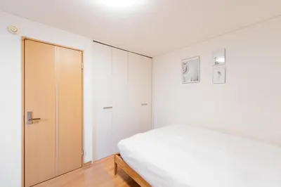 a white bedroom with a bed and a closet at \u65b0\u5bbf \u6b4c\u821e\u4f0e\u753a\u3059\u3050 \u8cb8\u5207\u4e00\u8ed2\u5bb6 \u6771\u65b0\u5bbf2\u5206 \u6700\u59278\u540d \u5168\u5ba4\u30a8\u30a2\u30b3\u30f3 \u30ad\u30c3\u30c1\u30f3\u8a2d\u5099\u5b8c\u5099 in Tokyo