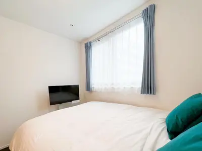 a bedroom with a white bed and a television at MAT OSHIAGE Ⅱ in Tokyo