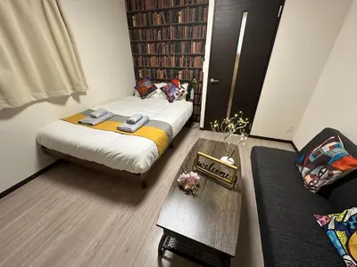 a small room with a bed and a couch at nestay inn tokyo asakusa in Tokyo