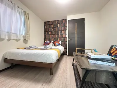 a bedroom with a bed and a desk and a table at nestay inn tokyo asakusa in Tokyo