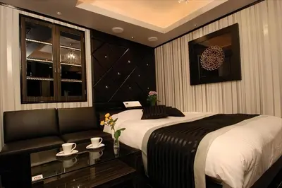 a bedroom with a large bed and a couch at HOTEL Shuffle in Tokyo