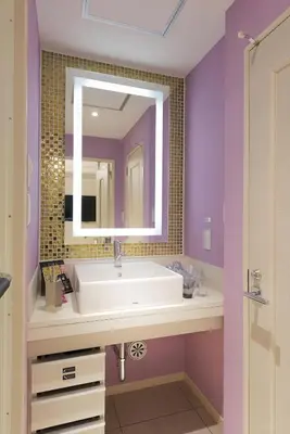 a bathroom with a white sink and a mirror at HOTEL REFRAIN in Tokyo