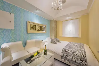 a bedroom with a king sized bed and a couch at HOTEL REFRAIN in Tokyo