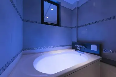 a blue bathroom with a tub and a window at HOTEL REFRAIN in Tokyo
