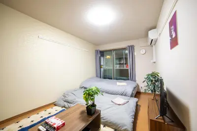 a small room with two beds and a table at Minimalism HOTEL TOKYO Katsushika in Tokyo