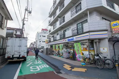 a man walking down a street next to a building at Minimalism HOTEL TOKYO Katsushika in Tokyo