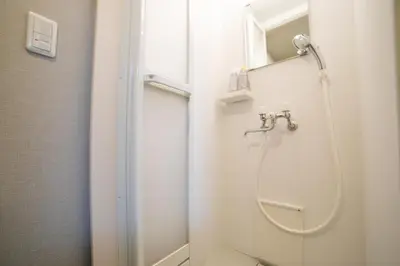 a shower in a white bathroom with a toilet at Minimalism HOTEL TOKYO Katsushika in Tokyo