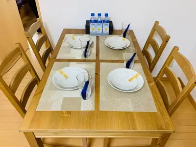a wooden table with plates and glasses and bottles of water at K&M Heights - Vacation STAY 20628v in Tokyo