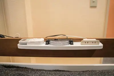 a table with a remote control on a shelf at Business Hotel Kankokukan in Tokyo