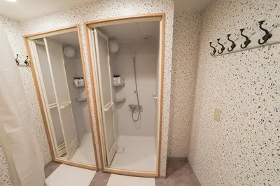 a shower with a glass door in a bathroom at Business Hotel Kankokukan in Tokyo