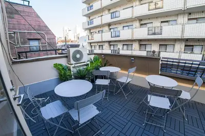 a balcony with tables and chairs on a building at Business Hotel Kankokukan in Tokyo