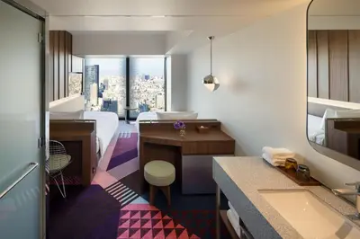 a hotel room with a bathroom with a bed and a desk at HOTEL GROOVE SHINJUKU, A PARKROYAL Hotel in Tokyo
