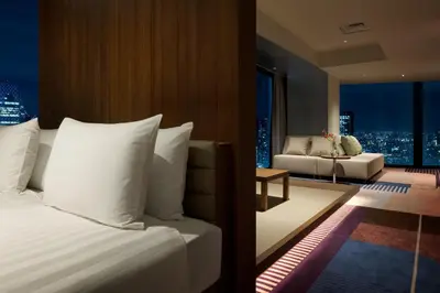 a bedroom with a bed and a living room with a couch at HOTEL GROOVE SHINJUKU, A PARKROYAL Hotel in Tokyo