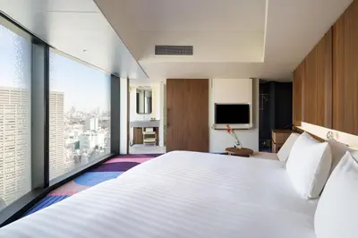 a hotel room with a large bed and a large window at HOTEL GROOVE SHINJUKU, A PARKROYAL Hotel in Tokyo