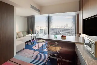 a kitchen and living room with a view of a city at HOTEL GROOVE SHINJUKU, A PARKROYAL Hotel in Tokyo