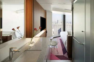 a hotel room with a view of a bedroom at HOTEL GROOVE SHINJUKU, A PARKROYAL Hotel in Tokyo