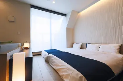 a bedroom with a large bed and a large window at stayme THE HOTEL\u6d45\u8349\u30ea\u30d0\u30fc\u30b5\u30a4\u30c9 in Tokyo