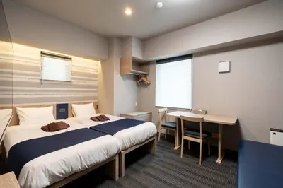 a bedroom with a bed and a desk and a table at stayme THE HOTEL\u4e0a\u91ce\u99c5\u524d in Tokyo
